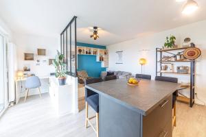 a kitchen and living room with a large island in a room at Le Jean Moulin - Appartement à 2 pas du tramway in Angers