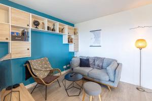 a living room with a couch and a chair at Le Jean Moulin - Appartement à 2 pas du tramway in Angers