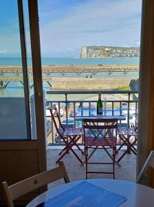 a table and chairs with a view of the beach at Balcon face à la mer in Le Tréport