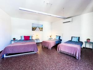 um quarto com duas camas com capas cor-de-rosa e azul em By Cathedral Rooms em Barcelona