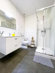a white bathroom with a shower and a toilet at By Cathedral Rooms in Barcelona