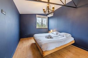 a bedroom with blue walls and a bed with a chandelier at Appartement vintage - Proche centre in Angers