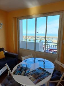 a living room with a table and a window at Balcon face à la mer in Le Tréport
