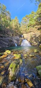 een stroom water met rotsen en een waterval bij PONTE DE LIMA - VILLA VIVENDA OLIVAL - Piscine privée entre mer et montagne in Canadelo