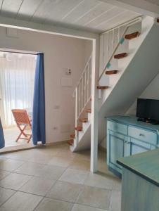 uma sala de estar com uma escada e um armário azul em Villetta Luna em San Teodoro