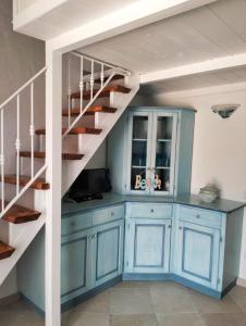 una cucina con armadi blu e una scala a chiocciola di Villetta Luna a San Teodoro