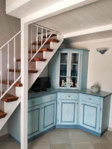a kitchen with blue cabinets and a spiral staircase at Villetta Luna in San Teodoro +10 photos
