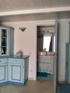 a kitchen with blue cabinets and a sink at Villetta Luna in San Teodoro