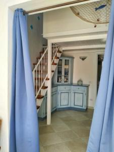 - un escalier dans une chambre dotée de rideaux bleus dans l'établissement Villetta Luna, à San Teodoro