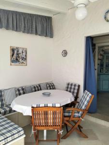 a dining room with a table and chairs and a couch at Villetta Luna in San Teodoro