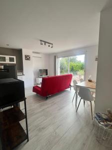 Una sala de estar con un sofá rojo y una mesa. en Charmant T2 calme , climatisé et piscine privée, en Marsella