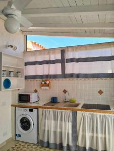 a kitchen with a sink and a washing machine at Villetta Luna in San Teodoro