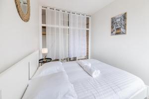 - une chambre blanche avec un lit et une fenêtre dans l'établissement Le Quartz - Appartement coquet gare, à Angers