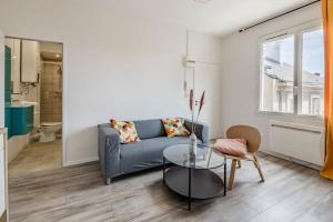 - un salon avec un canapé et une table en verre dans l'établissement Le Quartz - Appartement coquet gare, à Angers
