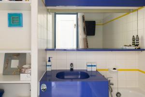 y baño con lavabo azul y espejo. en Joli studio sur le Port du Crouesty, en Arzon
