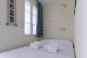 1 dormitorio con 1 cama con sábanas blancas y ventana en Joli studio sur le Port du Crouesty, en Arzon