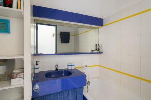 W łazience znajduje się niebieska umywalka i wanna. w obiekcie Joli studio sur le Port du Crouesty w mieście Arzon