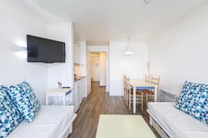 アルゾンにあるCharmant appartement vue sur le Crouestyのリビングルーム(白いソファ付)、キッチンが備わります。