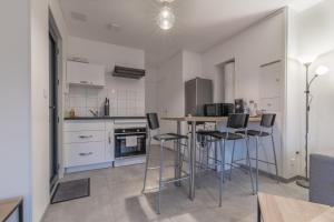 a kitchen with a table and chairs in a room at L'URBAIN - Appartement proche gare in Saint-Nazaire