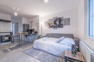 sypialnia z łóżkiem oraz kuchnia ze stołem w obiekcie L'URBAIN - Appartement proche gare w mieście Saint-Nazaire
