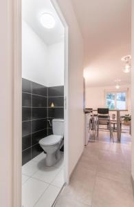 a bathroom with a toilet and a dining room at L'URBAIN - Appartement proche gare in Saint-Nazaire