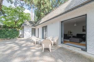 een patio met stoelen, een tafel en een bank bij LES ERABLES - Maison familiale in La Baule