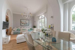 een woonkamer met een glazen tafel en een bank bij LE PRESTIGE - Bel appartement face mer in La Baule