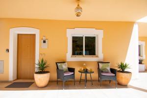 a porch with chairs and a table and a window at Casa Kantara in Ferragudo