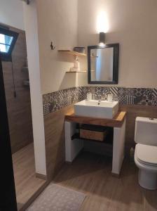 a bathroom with a sink and a toilet and a mirror at BRAMASOLE Charming House in Comiso