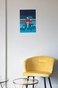 a yellow chair and a glass table in a room at LE DESIGN - Appartement vers la gare in La Baule