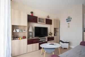 een woonkamer met een tv en een tafel bij LE VINTAGE - Appartement proche plage in Saint-Nazaire