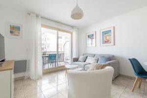 a living room with a couch and a table at LE NID - Appartement centre La Baule in La Baule