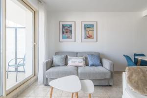 a living room with a couch and a table at LE NID - Appartement centre La Baule in La Baule
