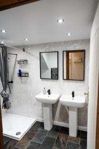 La salle de bains est pourvue de 2 lavabos et d'une douche. dans l'établissement Silverwood Loft, à Telford