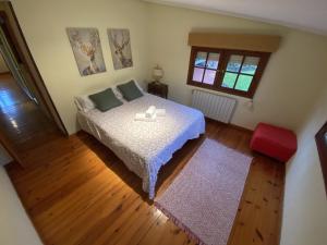 Schlafzimmer mit einem Bett mit einem Tisch und einem Fenster in der Unterkunft Casa estilo rural con jardín entre playa y montaña in Caravia