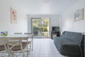 - un salon avec une table et un canapé dans l'établissement LES PETRELS - Appartement rez-de-jardin, à Pornichet