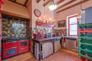 een keuken met rode apparatuur en kleurrijke tegels bij Grande maison 19p vue mer au Pouliguen in Le Pouliguen