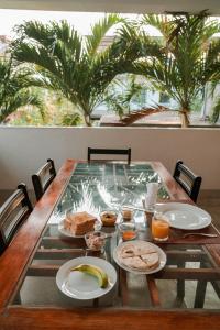 a table with plates of food on it with palm trees at Hotel Tobiko in Trincomalee