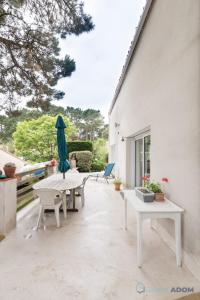 eine Terrasse mit einem Tisch, Stühlen und einem Sonnenschirm in der Unterkunft Belle maison familiale en bord de mer in Pornic