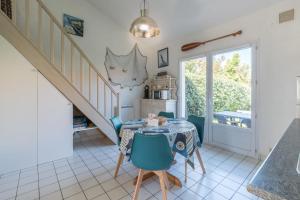 una sala da pranzo con tavolo e sedie blu di Maison résidentielle à 200 m de la mer a La Bernerie-en-Retz