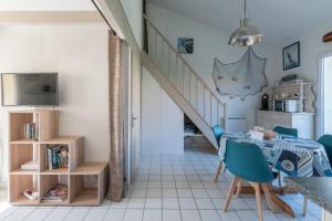 un soggiorno con tavolo e scala di Maison résidentielle à 200 m de la mer a La Bernerie-en-Retz