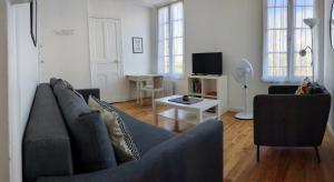 sala de estar con sofá y TV en T2 42 m² en Centre-ville de Cambo-les-Bains, en Cambo-les-Bains