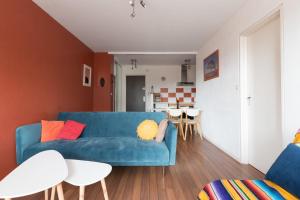 salon z niebieską kanapą i kuchnią w obiekcie Appartement à 200m de ThalassoSpa w mieście Pornic