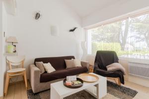 ein Wohnzimmer mit einem Sofa und 2 Stühlen in der Unterkunft Maison en résidence proche du vieux port in Pornic