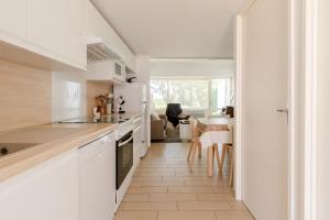 eine Küche mit weißen Geräten und ein Esszimmer in der Unterkunft Maison en résidence proche du vieux port in Pornic