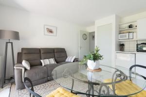 Appartement avec Golf tennis et mer في بورنيك: غرفة معيشة مع أريكة وطاولة زجاجية