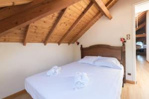 Schlafzimmer mit einem Bett mit weißer Bettwäsche und Holzdecken in der Unterkunft Les Maldives - face mer pour 6 personnes in La Plaine-sur-Mer