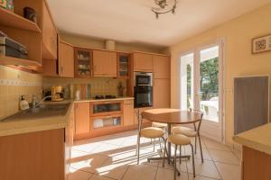 a kitchen with wooden cabinets and a table and chairs at Maison plain pied proche plage in Préfailles