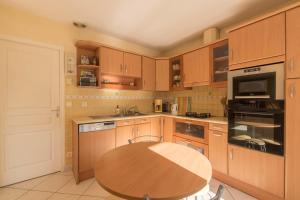 a kitchen with wooden cabinets and a wooden table at Maison plain pied proche plage in Préfailles