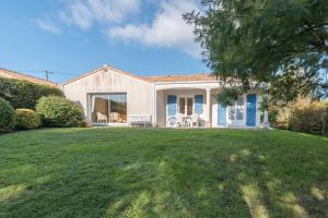 a house with a lawn in front of it at Maison plain pied proche plage in Préfailles